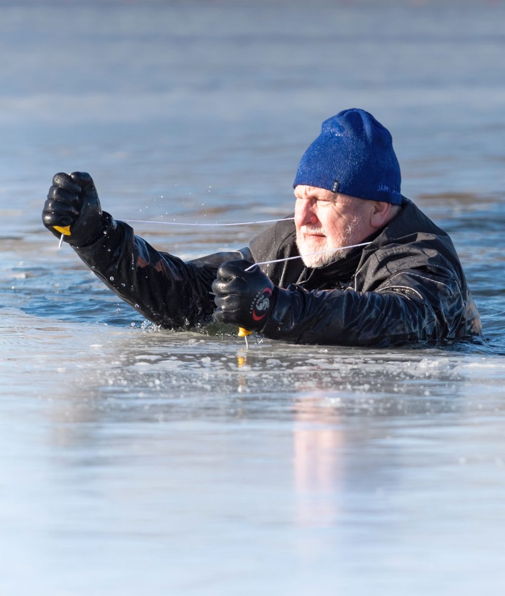 Loimun puheenjohtaja Jouni Vainio pelastautuu avannosta jäänaskalien avulla.